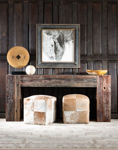 an old fireplace with two foot stools and a painting on the wall