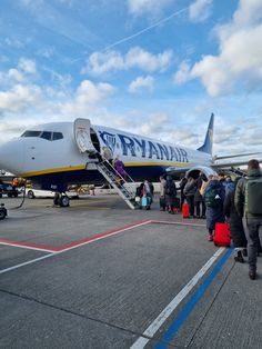 people are boarding an airplane on the tarmac