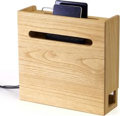 a wooden box with an electronic device in the middle and charging cord attached to it