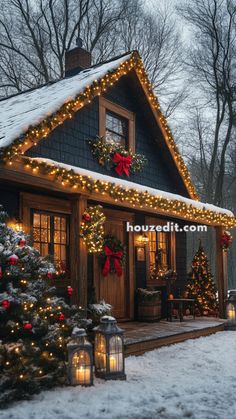 a house with christmas lights on the front porch and trees in the snow around it