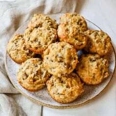 a plate full of carrot muffins on a white tablecloth with a napkin