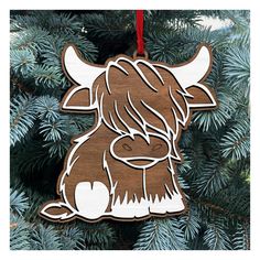 a wooden ornament shaped like a cow with long hair on it's head