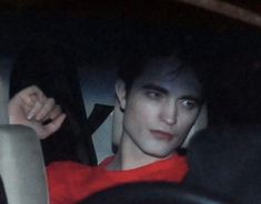 a young man sitting in the back seat of a car