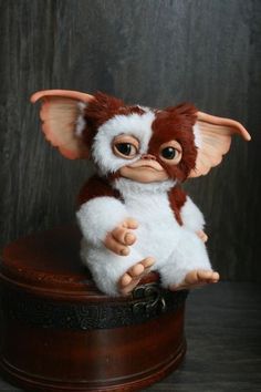 a small stuffed animal sitting on top of a wooden box