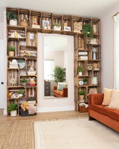 a living room filled with lots of furniture and shelves full of plants on top of them