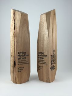 two wooden awards are shown side by side on a white background, one is for timber and the other is for innovation