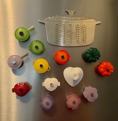 a stainless steel refrigerator covered in lots of different colored plastic knobs and strainers