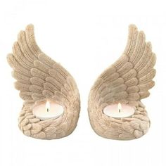 two angel wings with candles in them