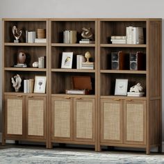 a bookcase with many books and pictures on the shelves in front of a rug