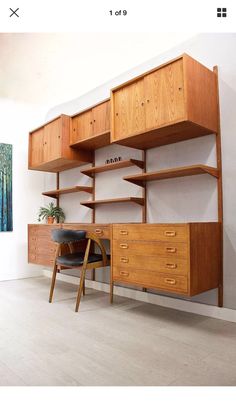 a wooden desk sitting next to a wall with shelves on each side and a potted plant in front of it