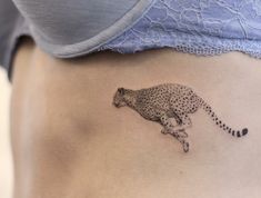 a woman's stomach with a tattoo of a cheetah running on it