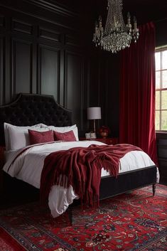 a bedroom with black walls, red curtains and a chandelier hanging from the ceiling