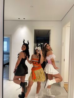 three women dressed in costumes taking a selfie