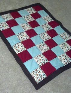 a red and blue quilt is laying on the floor with it's edges folded