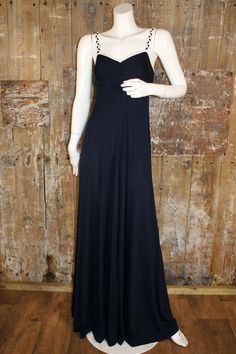 "Super classy 70s evening dress made for John Marks London by Anne Tyrrell. Made from a navy blue and white jersey, it drapes beautifully. It has a ruched bodice with sweetheart neckline and low cut back, with plaited shoulder straps. The skirt is closely fitted from the bust, flaring out over the hips. It`s a very flattering design. Labelled size 10, Ban-Lon polyamide. In my opinion would fit a UK 6, the fabric is quite stretchy. Measures 32\" bust, 27\" at underbust seam, 40\" hips. Length 60\" from shoulder to hem. It has a small hole in the white binding at the back, as shown in the close up picture. Otherwise in good vintage condition." 60s Cocktail Dress, Jersey Evening Dress, Navy Blue Maxi Dress, Halter Neck Maxi Dress, Blue Maxi Dress, Green Maxi, Ruched Bodice, Blue Maxi, Maxi Dress Evening