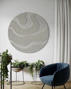 a living room with two chairs and a large circular metal wall decoration on the wall