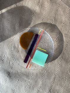 two different colored toothbrushes sitting on top of a glass plate