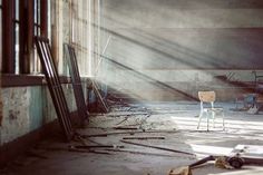 an empty chair sitting in the middle of a room with no one around it and debris on the floor