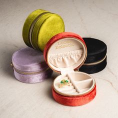 three different colored velvet jewelry boxes with rings inside