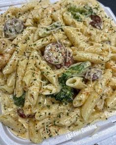 a plastic container filled with pasta and broccoli