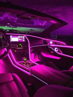 the interior of a car with purple lighting