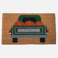 a welcome mat with pumpkins in the back of a pick up truck that says welcome