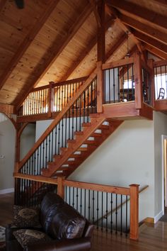 a living room filled with furniture and wooden stairs