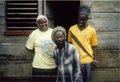 three people standing next to each other in front of a building