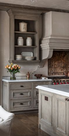 a kitchen with gray cabinets and white counter tops