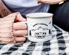 a person holding a coffee mug with the words happy campers on it