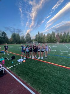 a group of young women standing on top of a soccer field