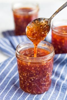 a spoon full of jam on top of a blue and white towel with striped cloth