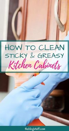 a person in blue gloves is cleaning the kitchen cabinets