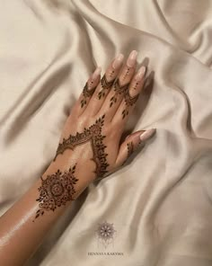 a woman's hand with henna tattoos on it