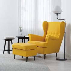 a yellow chair and ottoman in a white room