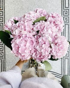 a person holding a bouquet of pink flowers