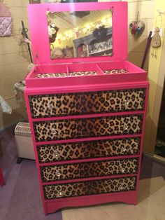 a pink dresser with leopard print drawers and mirror