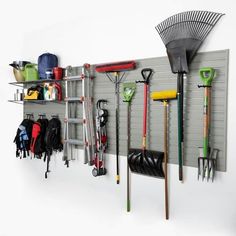 there is a wall with many different tools hanging on it and two shelves holding various items