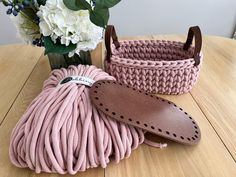 pink cord and leather shoelaces on wooden table next to white hydrangeas