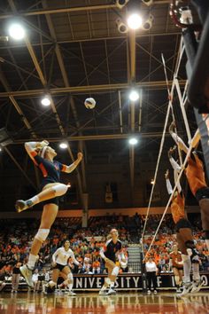 a group of women playing volleyball on a court