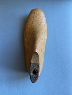 an old wooden object on a blue surface