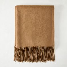 a tan blanket with fringes on it