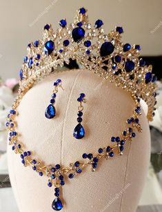 a blue and gold tiara with matching earrings on top of a mannequin