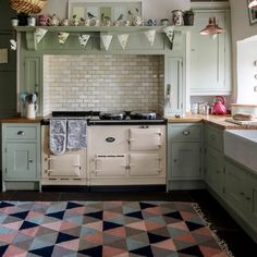 a kitchen with green cabinets and an oven