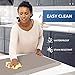 a woman standing in front of a table with food on it and an advertisement behind her