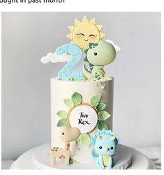 there is a two tiered cake with animals on it and the number one in the middle