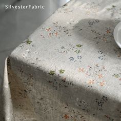 a white plate sitting on top of a table next to a cup and saucer