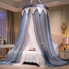 a canopy bed with blue and white drapes