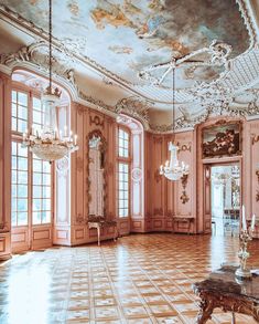 an ornately decorated room with chandeliers and paintings on the walls, in pink hues