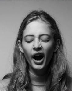 a woman with her mouth open making a surprised face while looking down at the camera